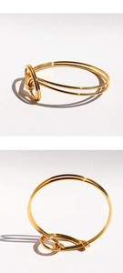 Close-up of golden multi-layer knot bracelet with mirror-finish metallic texture