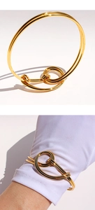 Detailed view of a gold-plated wire knot cuff bracelet with polished finish and layered design