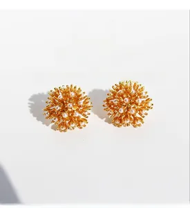 Detailed macro shot of vintage firework flower stud earrings with pearls and gold plating