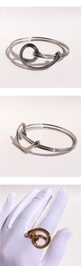 Detailed view of silver knotted open cuff and gold knot ring set with polished finish