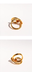 Detail of polished gold interlaced knot rings with a modern multi-layer stacked design