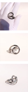 Close-up of interlocking silver knots and multi-layer polished rings in a luxury style