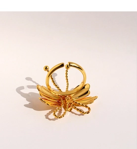 Gros plan sur la bague papillon dorée avec ailes superposées et anneau ajustable