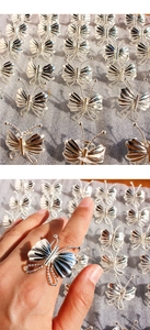 Gros plan d'une bague papillon 3D faite à la main avec ailes en métal texturées