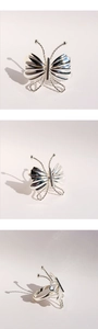 Vue macro d'une bague papillon 3D avec ailes plissées et texture de fil de métal torsadé