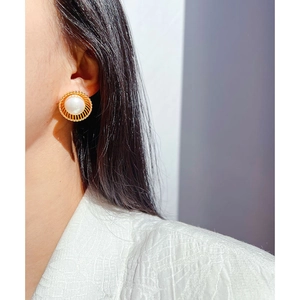 Boucles d'oreilles vintage avec perle oversize et monture dorée ajourée sur modèle