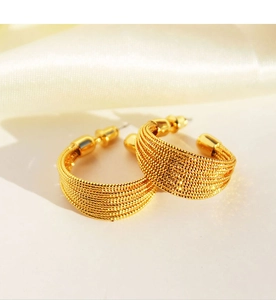 Close-up of gold C-shaped hoop earrings with layered brushed metal wire texture