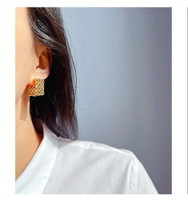 Detail view of gold square mesh woven earrings on model for a modern vintage look