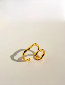 Detailed close-up of golden irregular wavy double-layer ear cuff with hammered texture