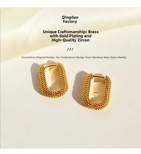 Detailed macro view of gold-plated U-shaped earrings with textured granular surface