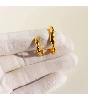 Detailed view of gold double-layer textured ear cuffs with irregular hammered finish