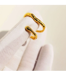 Macro shot of gold double-layer ear cuff with organic lava texture and wavy finish
