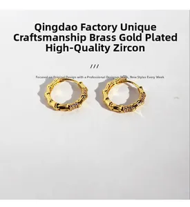 Macro shot of bamboo-shaped gold hoop earrings with sparkling cubic zirconia inlay