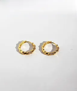 Macro detail of golden bamboo knot earrings with micro-inlaid zircon crystals
