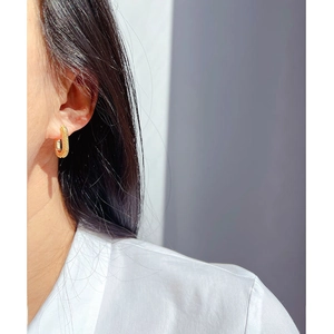 Chic gold rectangular hoop earrings with textured beaded rows worn on a model's ear