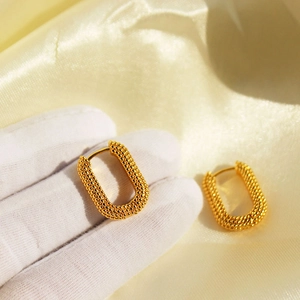 U-shaped gold hoop earrings with textured caviar finish and vintage huggie design