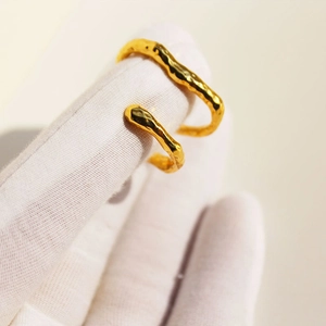 Minimalist double-layered gold ear cuff with organic lava texture shown on hand