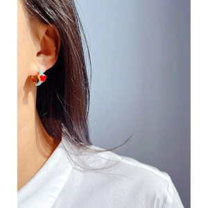 Blue enamel hoop earrings with red heart pendants shown as a worn-on-ear detail