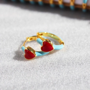 Handmade light blue enamel hoop earrings with a bright red heart and golden finish