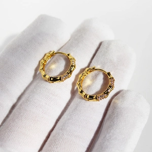 Minimalist gold bamboo style hoop earrings with shimmering cubic zirconia stones
