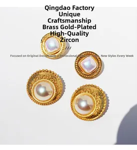 Dettaglio di orecchini vintage in pizzo dorato con perla e zircone su placcatura ottone
