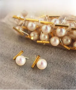 Detail presentation of round white pearl earrings with gold bar studs for daily wear