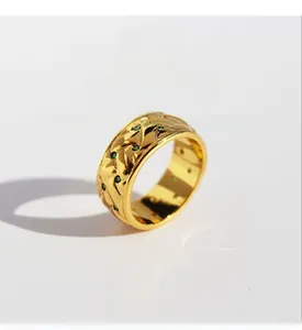 Macro detail of gold-plated lattice band ring with embedded green zircon stones