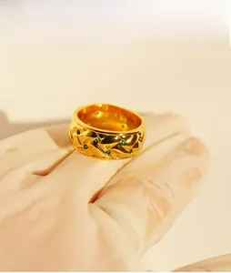 Detail showing vintage gold wide ring with woven texture and green zircon stones
