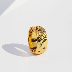 Vintage quilted gold ring with green zircon stones on a white background