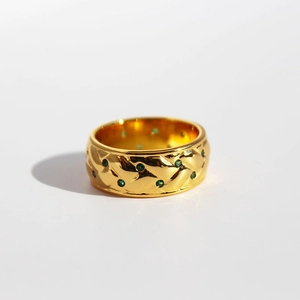 Vintage gold textured wide ring featuring green zircon stones on a white background