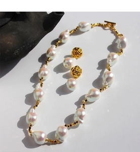 Dettaglio set collana di perle barocche e orecchini a perno con rosa dorata vintage