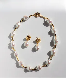 Dettaglio del set di gioielli con perle barocche, orecchini a rosa e collana