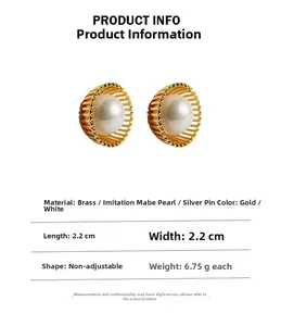 Vue détaillée des boucles d'oreilles dorées en forme de coquille avec perles blanches