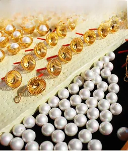 Détail de bélières dorées et perles blanches pour la création de bijoux DIY