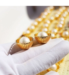 Vue macro de boucles d'oreilles perles avec monture dorée ajourée et éclat naturel