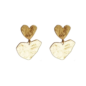 Golden double heart earrings with irregular hammered texture on white background