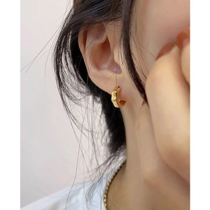 Polished gold bamboo-style hoop earrings shown on model for daily minimalist fashion