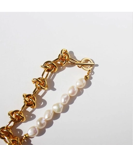 Close-up of golden chunky chain link bracelet with baroque pearls and OT toggle clasp