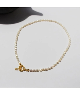 Macro view of freshwater rice pearl necklace featuring a vintage gold OT toggle clasp