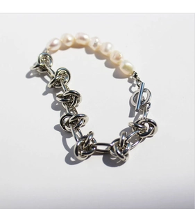 Macro detail of natural freshwater pearl bracelet with knotted silver chain and OT clasp