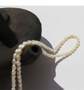 Close-up of natural rice-shaped freshwater pearls with vintage vine OT clasp necklace