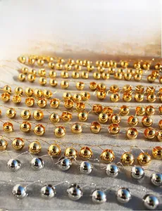 Macro shot of polished hollow metal ball earrings in gold and silver finish