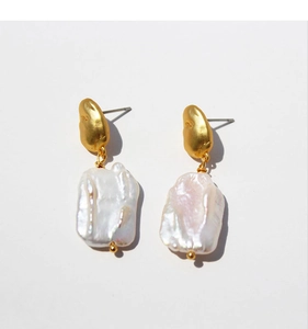 Détails de boucles d'oreilles en perles baroques avec placage or sur fond blanc
