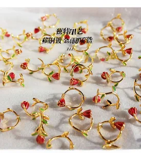Detail of red enamel rose earrings with gold plating and sparkling zircon accents