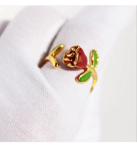 Detail of red enamel rose ring with golden band and green leaves in French vintage style