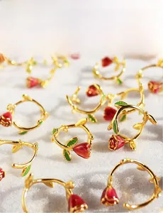 Detailed view of handcrafted red enamel rose jewelry with vintage gold finish