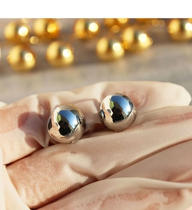 Macro shot of mirror-polished hollow spherical earrings in a minimalist silver finish
