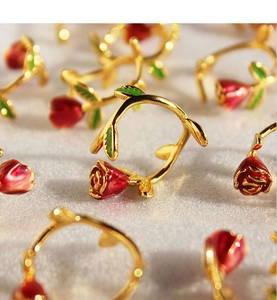 Macro shot of handcrafted red enamel rose ring with vintage gold-plated vine details