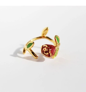 Detail of vintage red enamel rose ring with green leaves on gold vine band