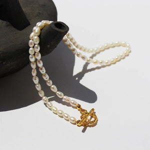 Elegant freshwater rice pearl necklace with vintage gold OT toggle clasp on ceramic decor